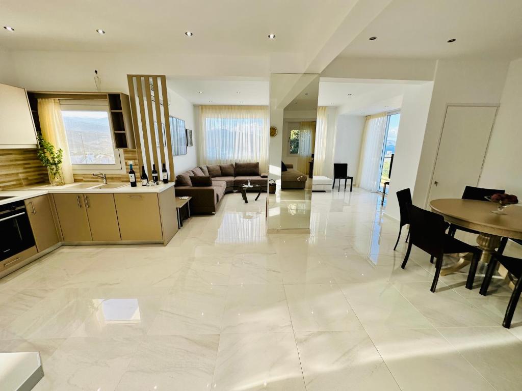 cocina grande y sala de estar con sofá y mesa en Villa Praxia i, en Kalo Chorio