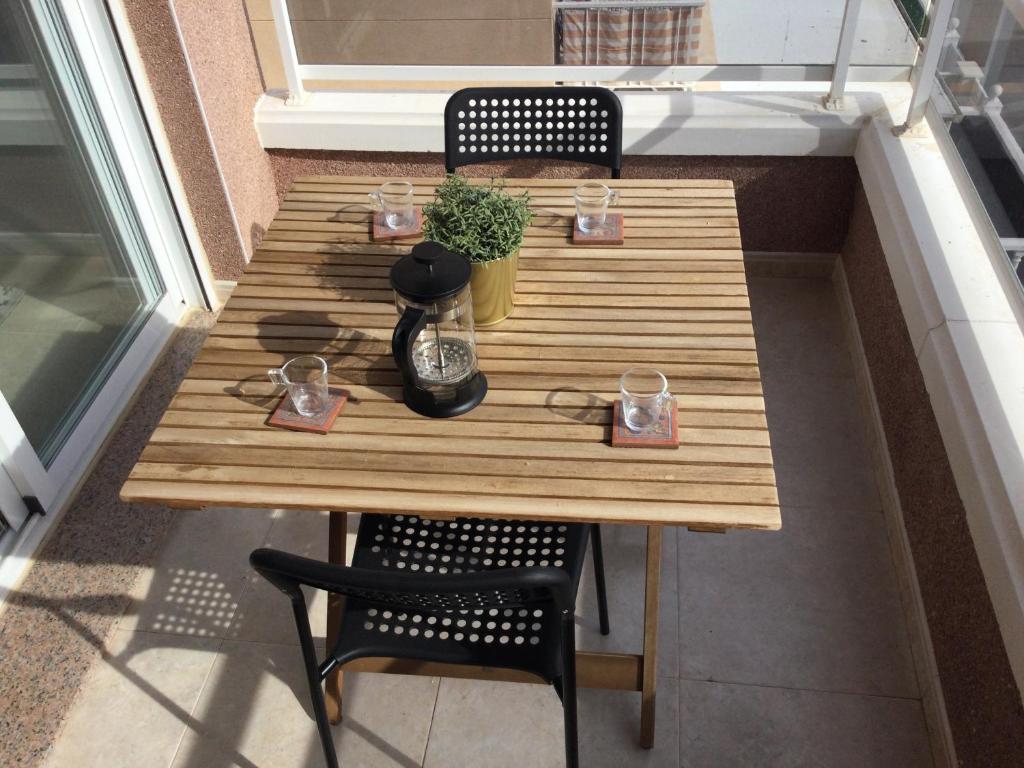 a wooden table on a balcony with two chairs and a table at Montgo 2 Bellreguard in Bellreguart