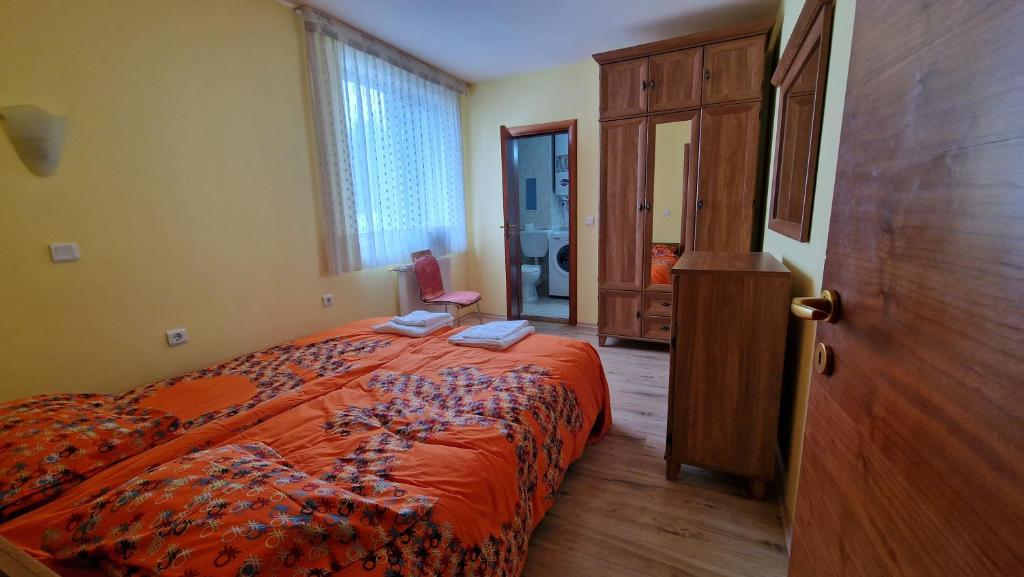 a bedroom with a bed with an orange blanket at Apartment 9 in Pamporovo