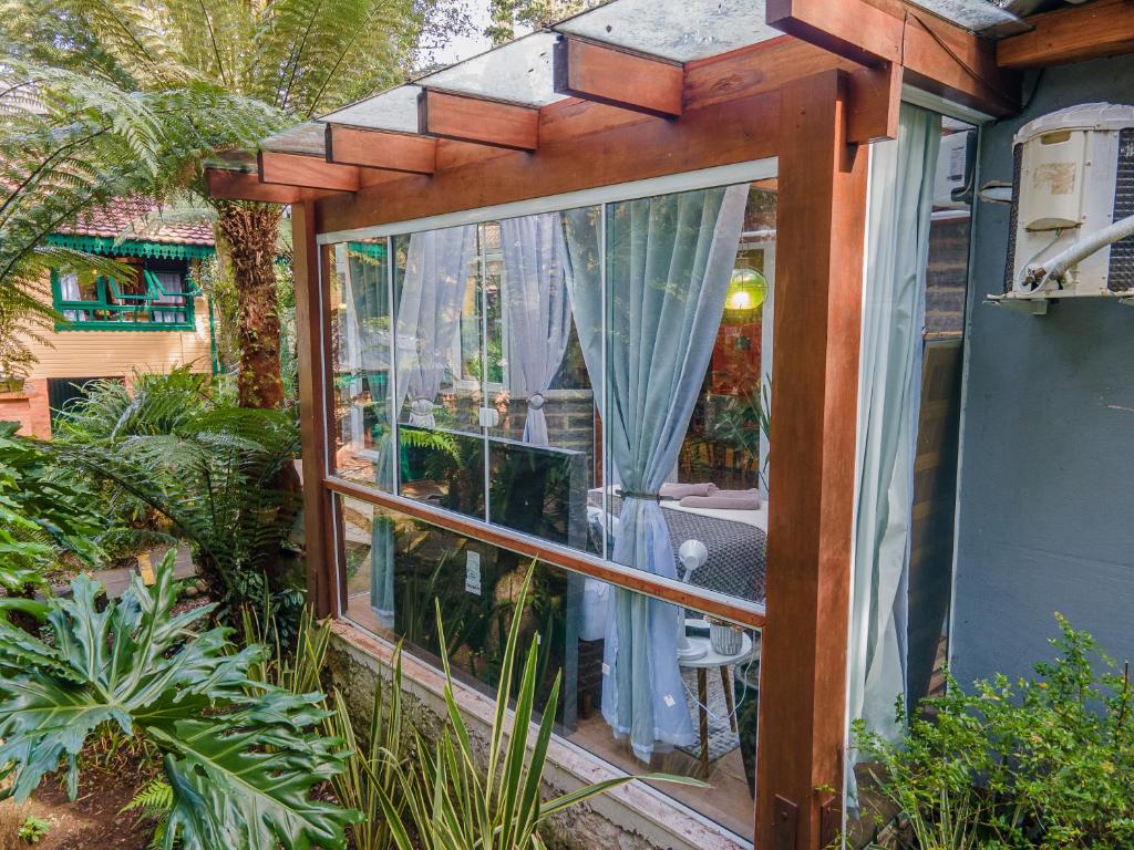 a garden room with a window and plants at Lala Haus Gramado in Gramado