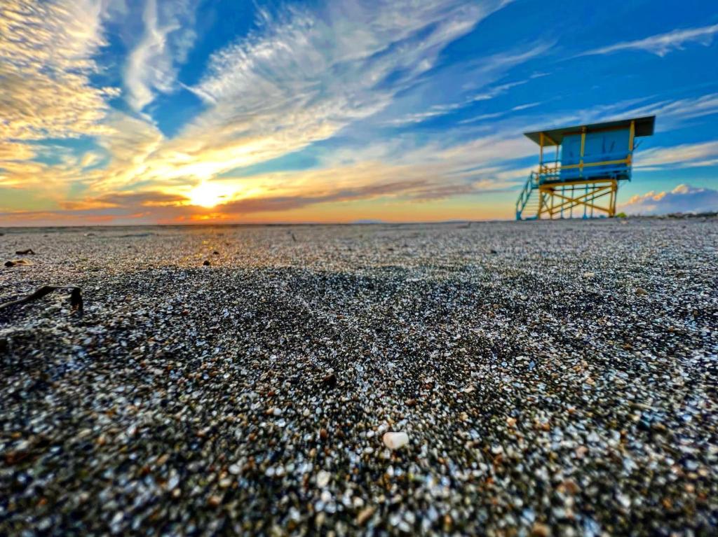 uma torre de salva-vidas na praia ao pôr-do-sol em Camping Village Tuscia Tirrenica em Tarquinia