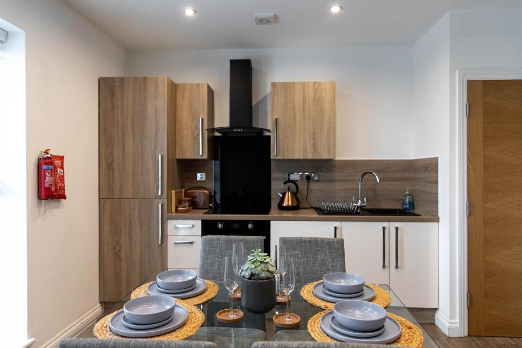 Hotel Stylish Jewellery Quarter Apartment Sleeps 6, a kitchen with a table with dishes on it at Stylish Jewellery Quarter Apartment Sleeps 6 in Birmingham