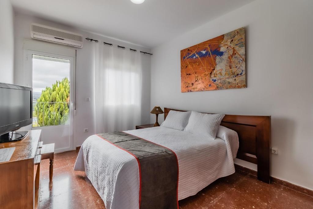 1 dormitorio con 1 cama, TV y ventana en Hotel Las Errizas by Vivere Stays, en Alcalá del Valle