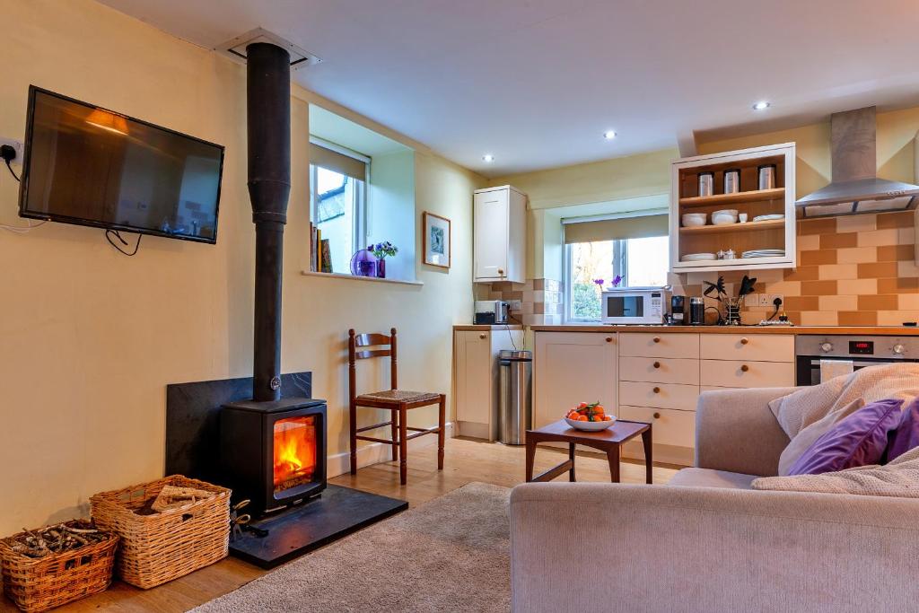 a living room with a fireplace and a couch at Finest Retreats - Jenny Wren in Boscastle