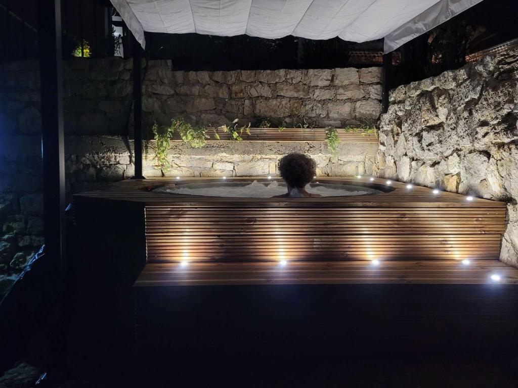 una persona en un jacuzzi en una habitación con luces en Les lodges de l'oliveraie de Virevent, en Grasse