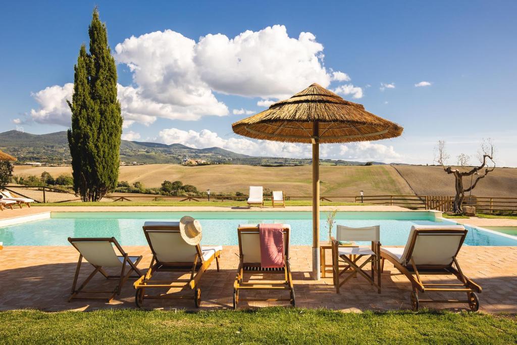 a group of chairs and an umbrella next to a pool at Le Fraine - Agriturismo & Olives Glamping in Santa Luce