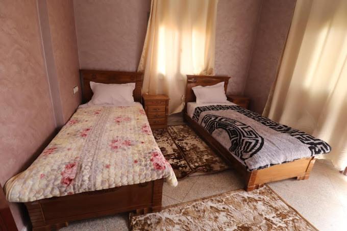 two beds in a small room at residance annawrasse in Laayoune