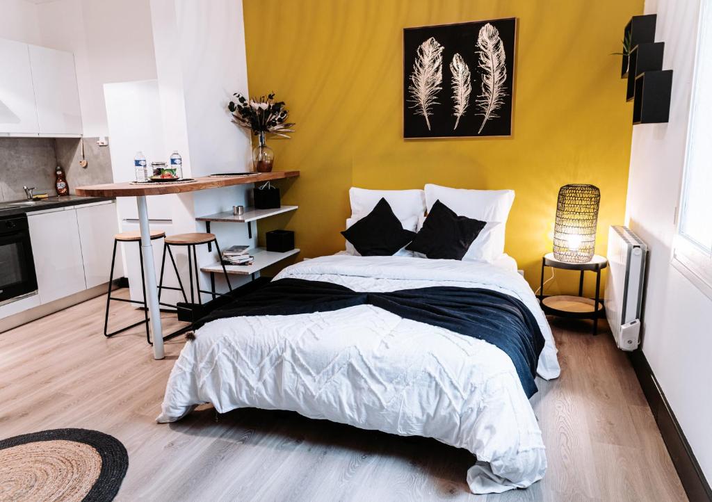 een slaapkamer met een bed en een gele muur bij Yellow Studio - Arrivée Autonome in Châtellerault