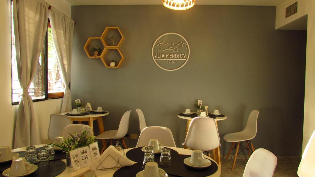 um restaurante com mesas e cadeiras e uma placa na parede em Hotel Alta Mendoza em Mendoza