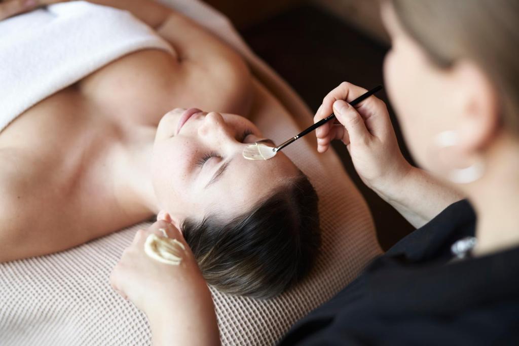 a woman is getting her eyelashespectedbestosbestosbestosbestosgress at Holzhotel Forsthofalm in Leogang