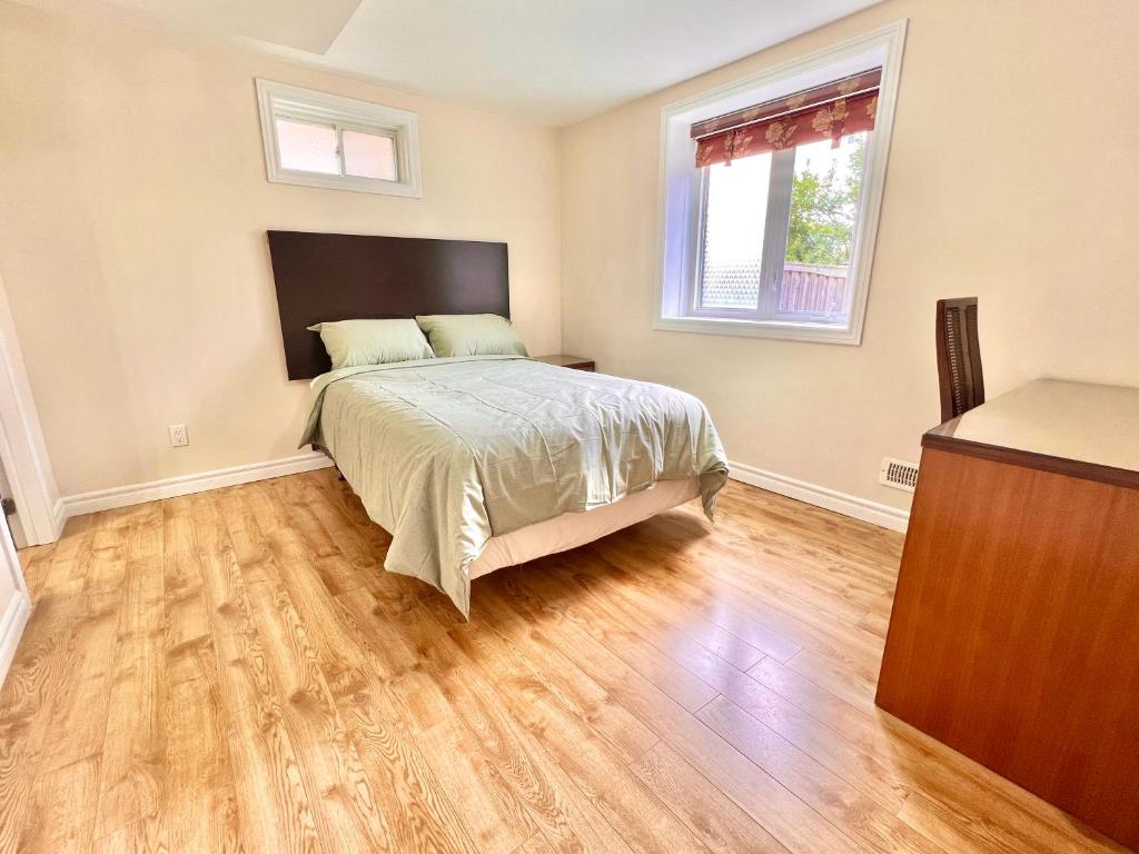Schlafzimmer mit einem Bett und Holzboden in der Unterkunft Cozy Detached Home in Richmond Hill in Richmond Hill
