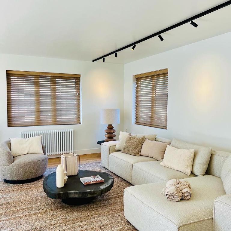 ein Wohnzimmer mit 2 Sofas und einem Tisch in der Unterkunft luxe appartement op topligging in Knokke-Heist