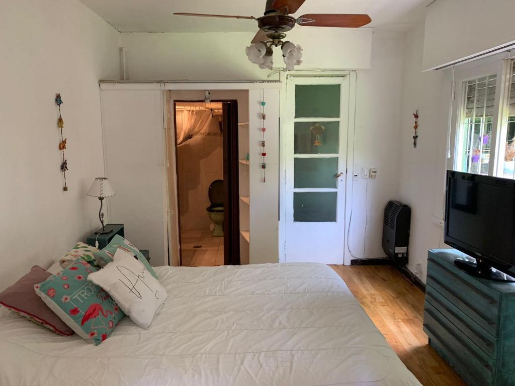 1 dormitorio con 1 cama y TV de pantalla plana en Departamento con habitación, cocina y baño privado barrio la perla en Mar del Plata