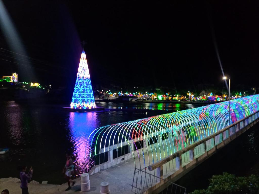 uma árvore de Natal na água ao lado de uma ponte em SUITES VISTA MAR AZUL em Saquarema