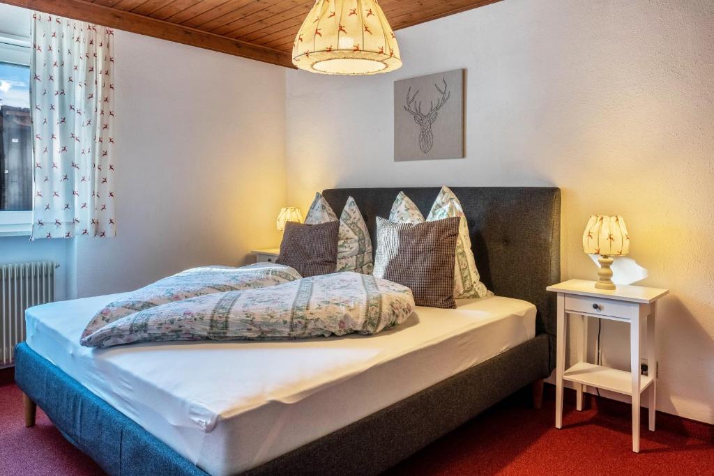 a bedroom with a bed and a chandelier at Sirena Carezza Apartment Karersee in Carezza al Lago