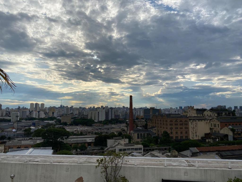 聖保羅的住宿－LINDO LOFT, PISCINA, ESTACIONAMENTO, ACADEMIA, AR CONDICIONADO, Wi-Fi，天空阴云下的城市景观
