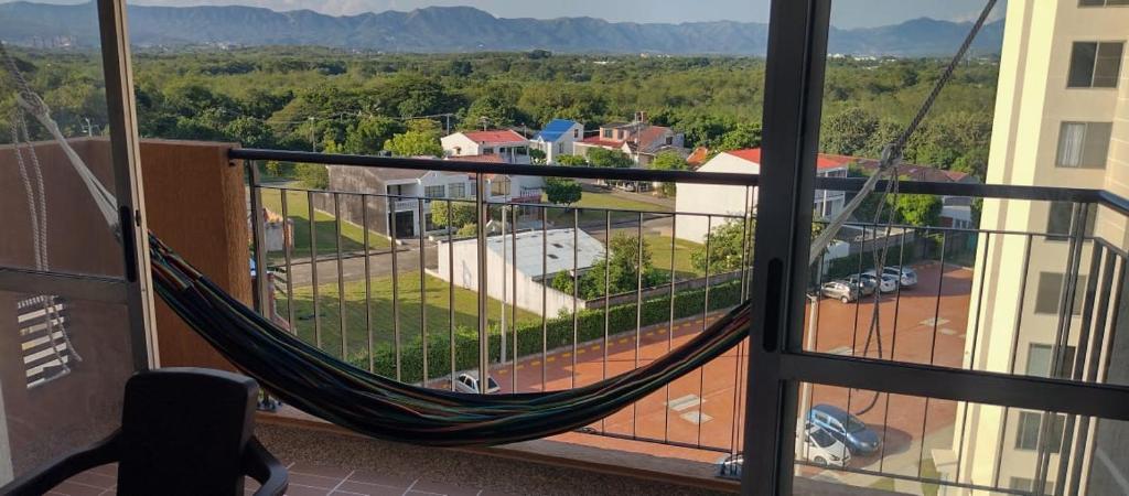 a hammock on a balcony with a view of a parking lot at Cómodo Apartamento, Hacienda Peñaliza - Ricaurte in Ricaurte