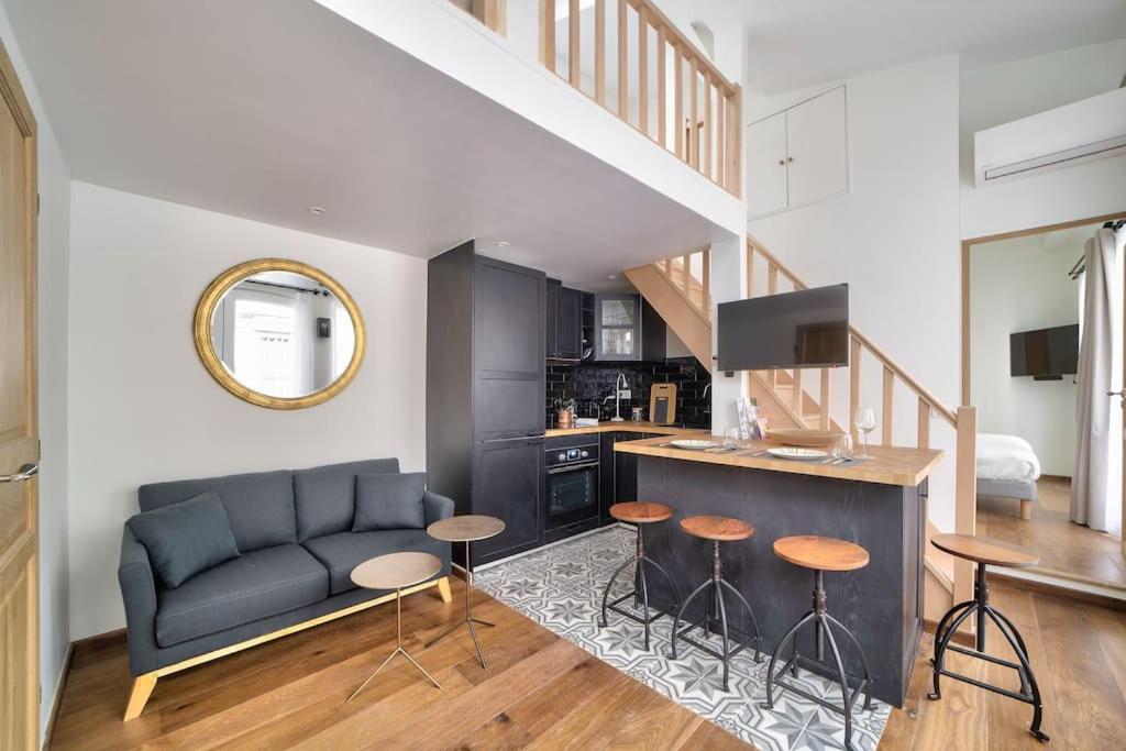 ein Wohnzimmer mit einem Sofa und einer Küche in der Unterkunft Superbe maisonnette neuve au coeur de Paris in Paris