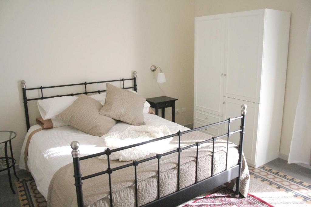 - une chambre avec un lit doté de draps et d'oreillers blancs dans l'établissement Le Stanze di Ariosto, à Palerme