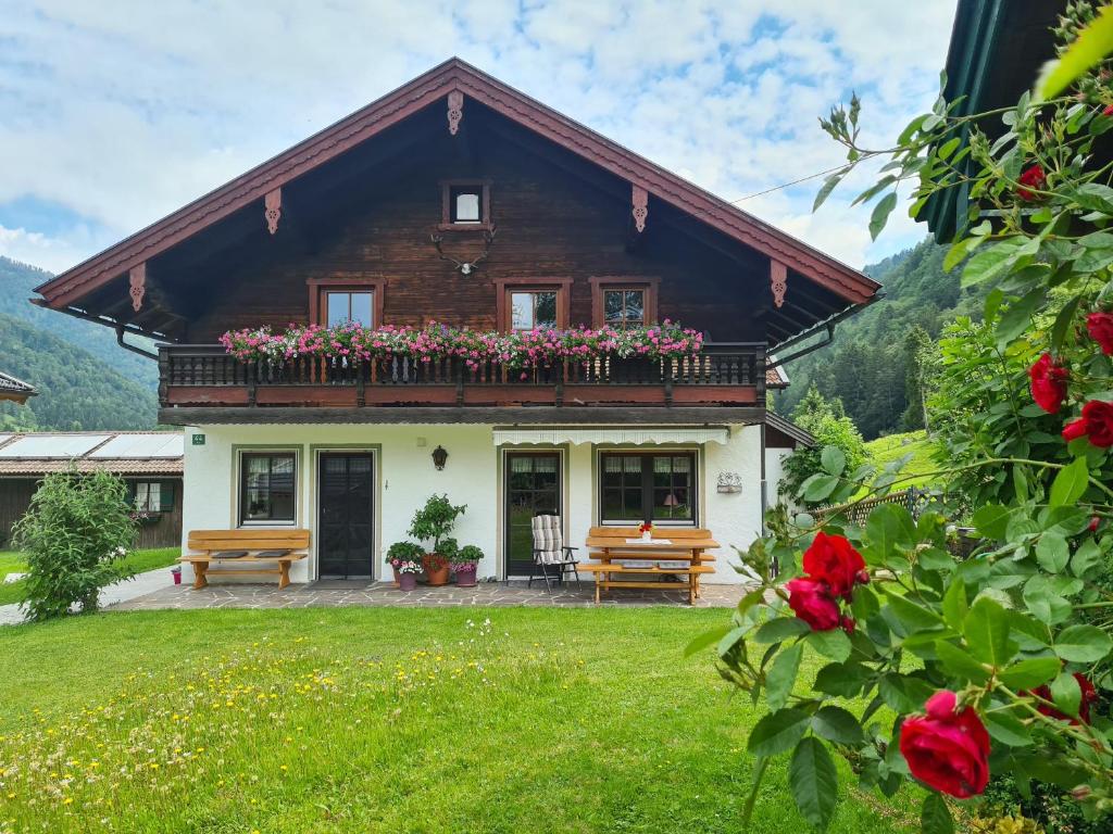 a house with a balcony with flowers on it at Ferienwohnungen Hamberger in Sachrang