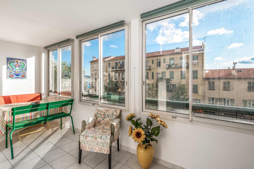 Cette chambre dispose de fenêtres, d'un bureau et d'une chaise. dans l'établissement Appartement California - Welkeys, à Nice