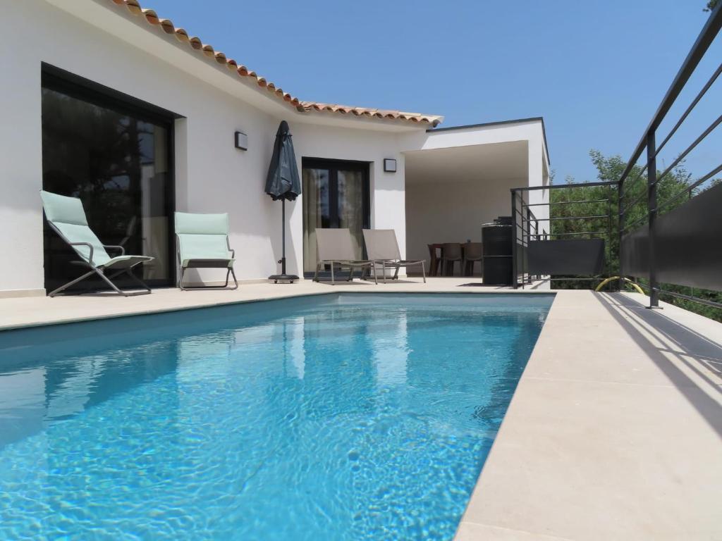 een zwembad voor een huis bij Les Villas de la Résidence U Veniqui in Favone