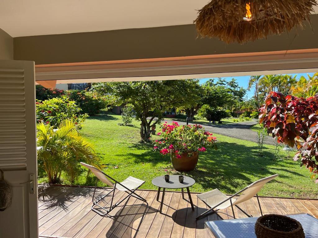 Un patio con una mesa y sillas en una terraza. en - Les pieds dans l'eau à 50m de la plage, côté mer caraïbe - Domaine de l'Anse CARITAN - Sainte-Anne -, en Sainte-Anne