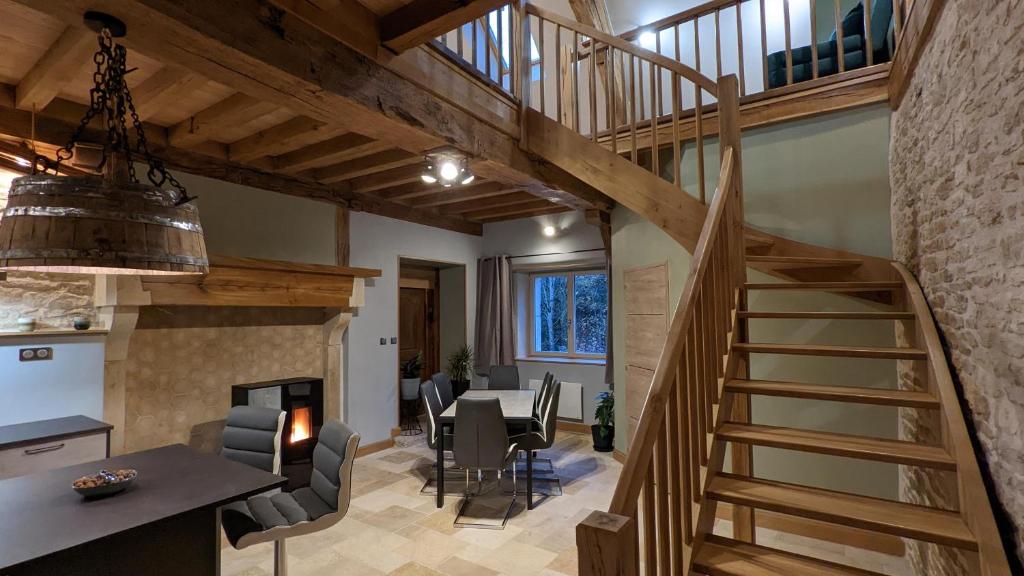 eine Küche und ein Esszimmer mit einer Treppe in einem Haus in der Unterkunft La Ferme du Château in Beire-le-Châtel