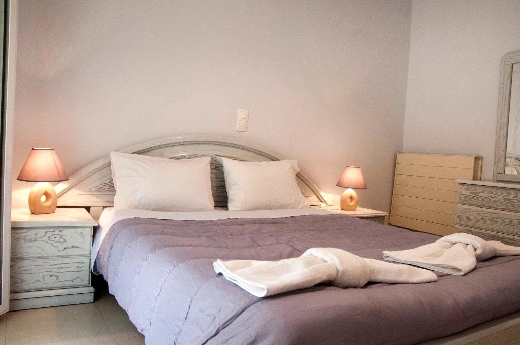 a bedroom with a large bed with two lamps at angelikashouse,big house in Corfu Town