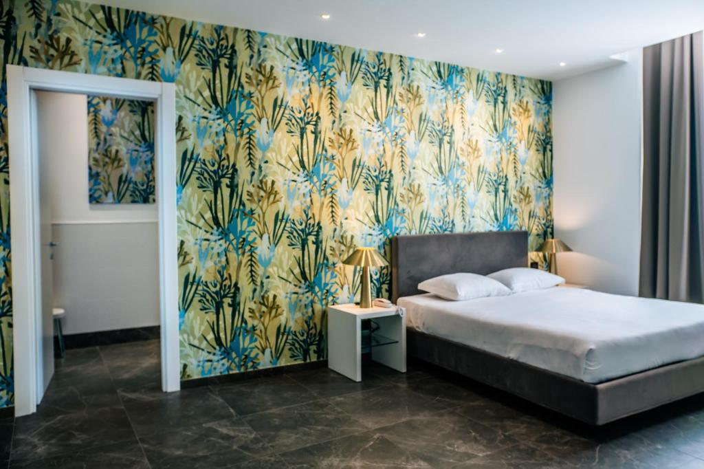 una camera da letto con un letto e carta da parati blu e gialla di Hotel Up Wellness & Spa a Foggia