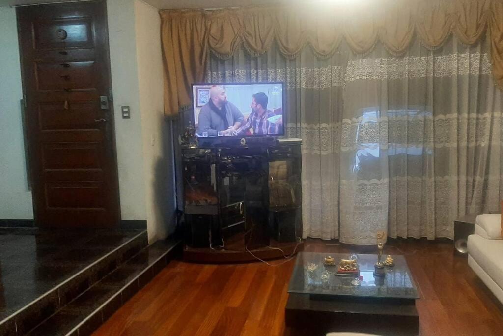 sala de estar con TV y sofá en Amplio Departamento Residencial en La Molina, en Lima