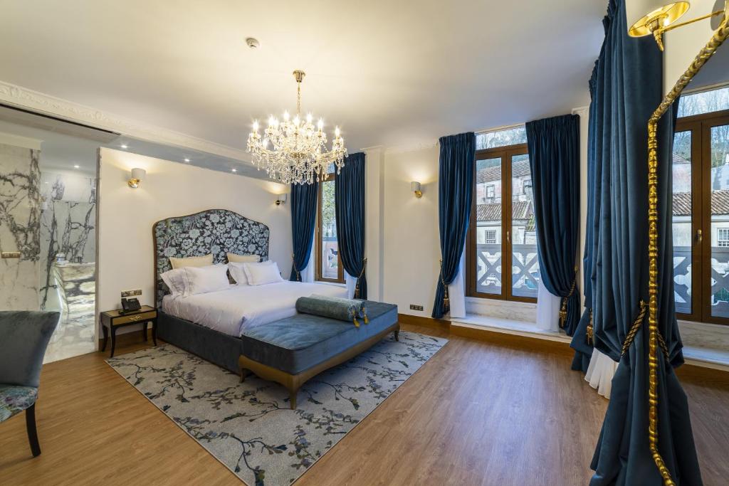 a bedroom with a bed and a chandelier at Sintra Marmòris Camélia in Sintra