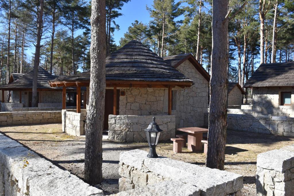 un edificio in pietra con panchina e padiglione di Alvão Village & Camping 