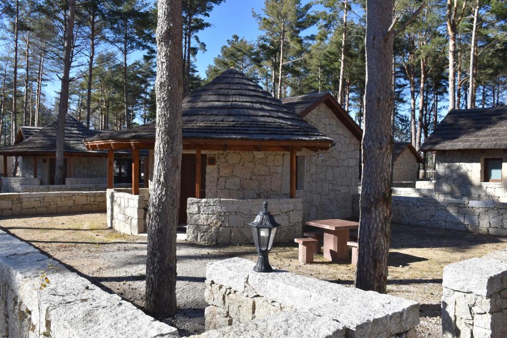 un edificio de piedra con un banco y un pabellón en Alvão Village & Camping 