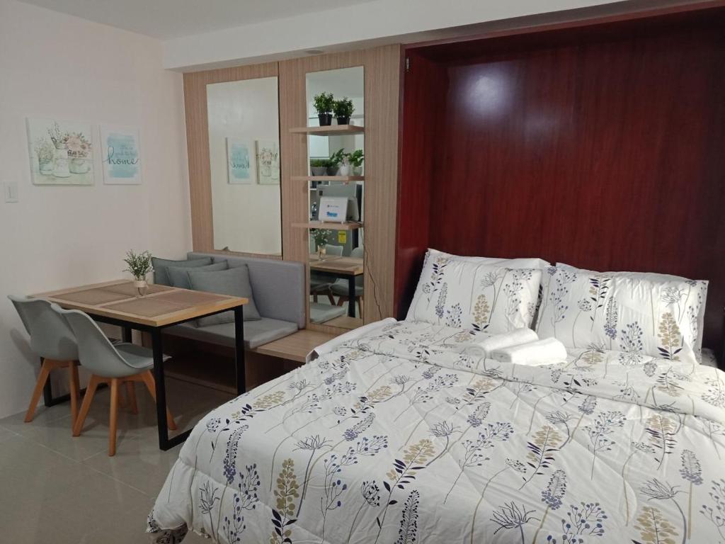 ein Schlafzimmer mit einem Bett und einem Tisch sowie ein Esszimmer in der Unterkunft Cozy1233 studio at The Persimmon in Cebu City