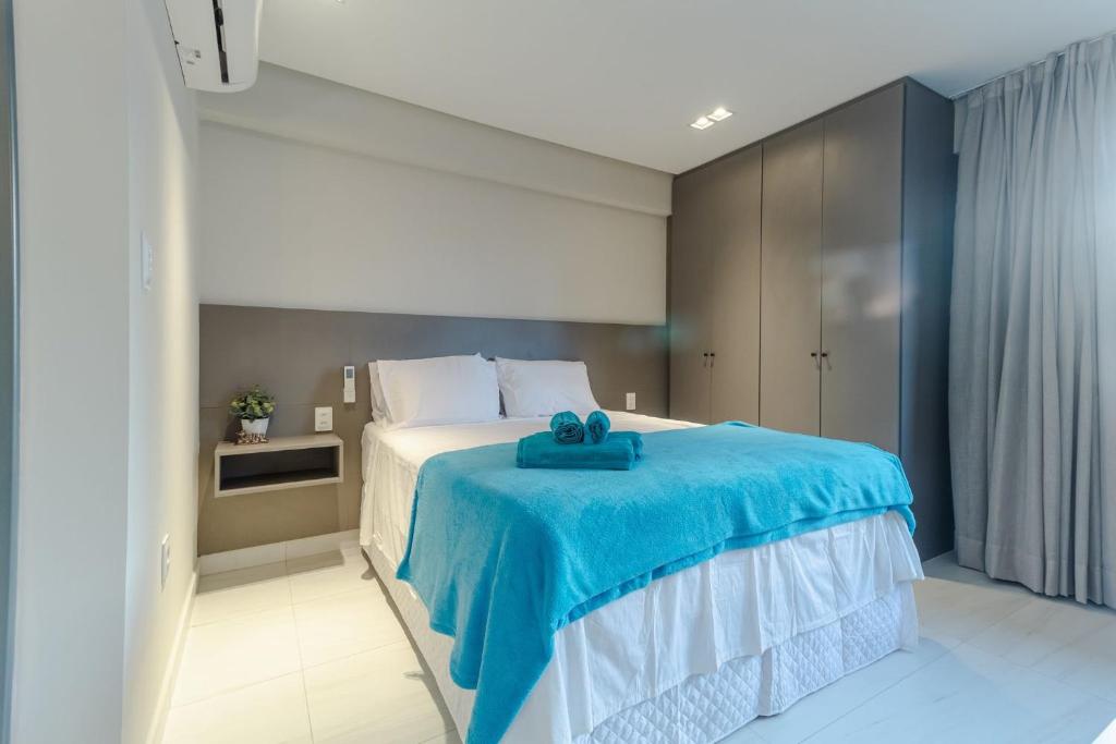 um quarto com uma cama com uma toalha azul em Mardisa Design - Luxo e Requinte em Cabo Branco por Carpediem em João Pessoa