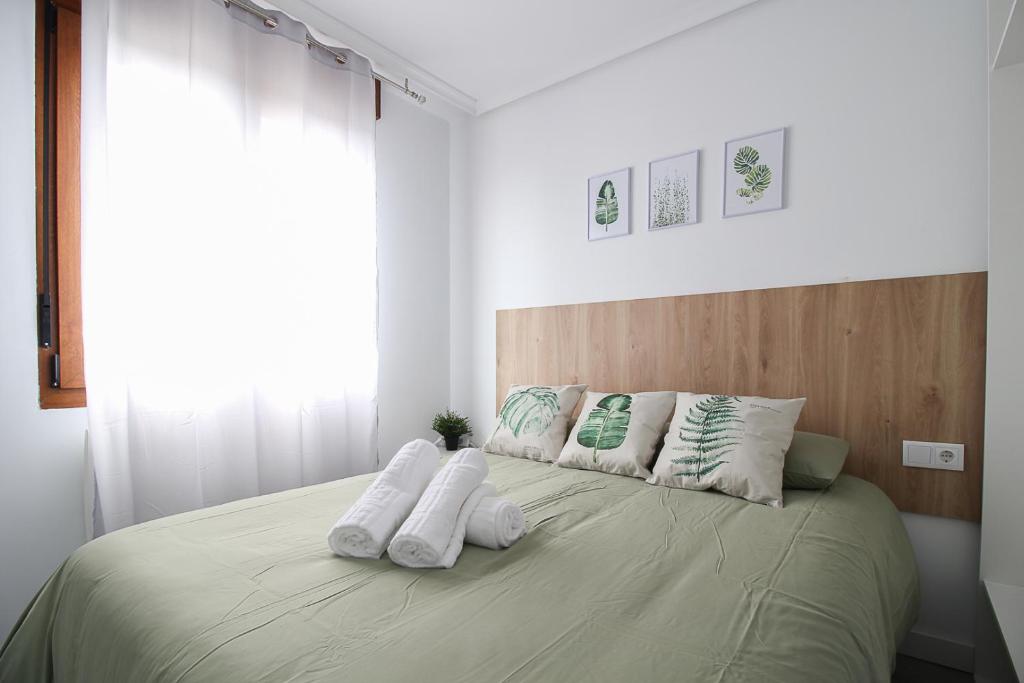 Un dormitorio con una cama con almohadas blancas. en loft con office santander, en Santander