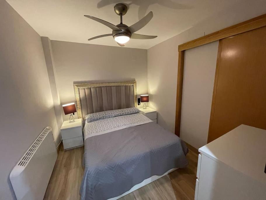 um quarto com uma cama e uma ventoinha de tecto em Encantador Apartamento en pleno Centro em Jaén