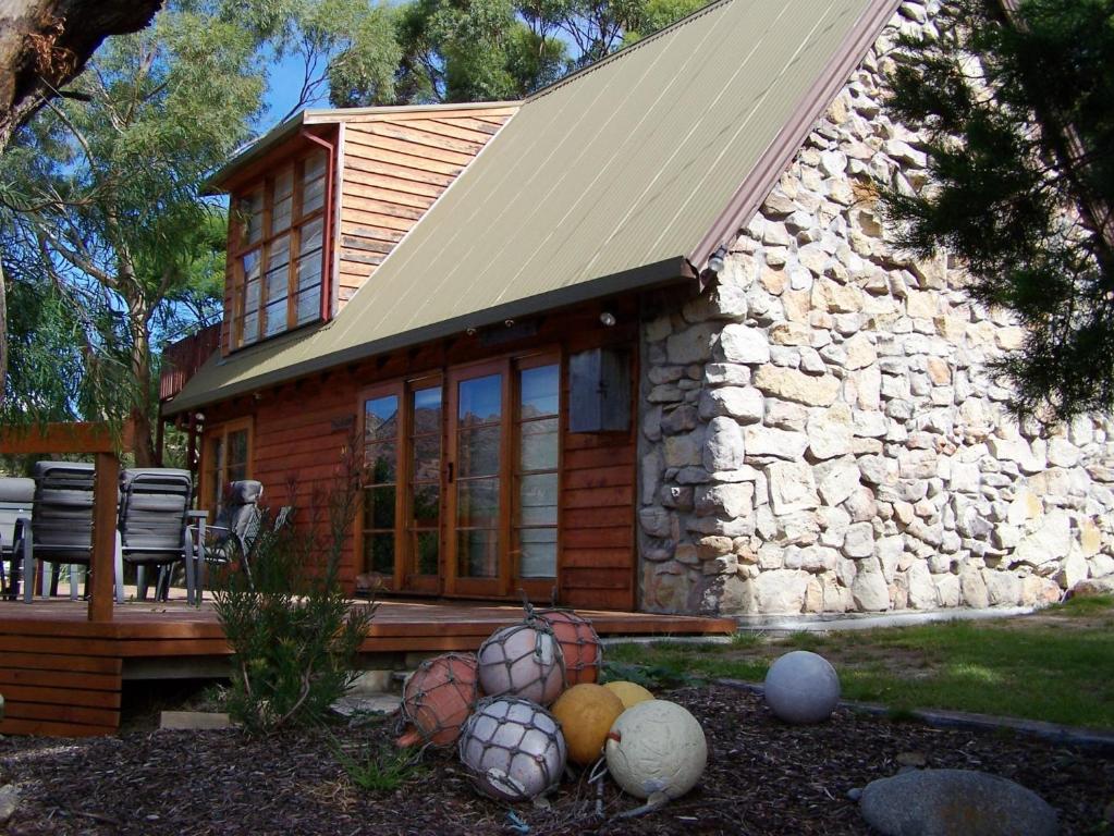 a log cabin with a bunch of balls in front of it at 81 on Freycinet in Coles Bay