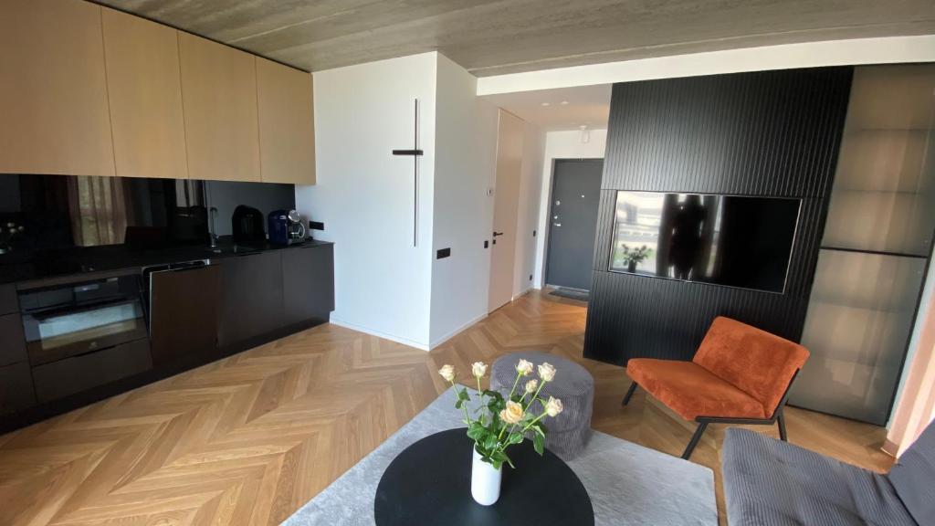 een woonkamer met een tafel en een keuken bij J. Ralio apartamentai in Vilnius