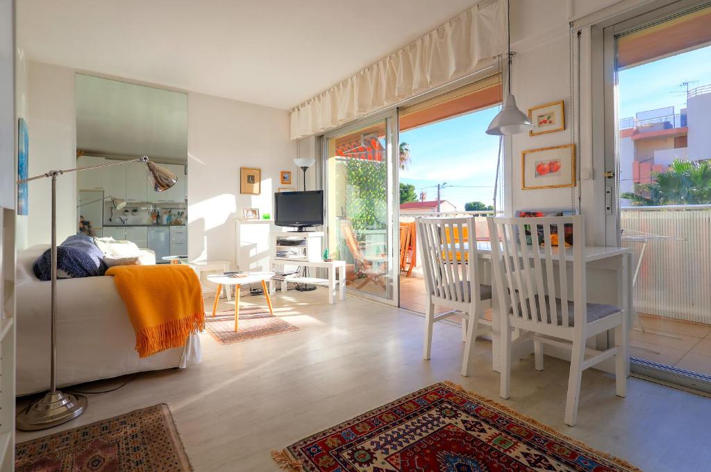a living room with a bed and chairs and a balcony at Le lutin in Saint-Laurent-du-Var