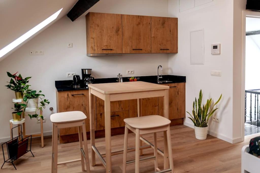 a kitchen with wooden cabinets and a island with stools at Miniloft Pelgrim in Antwerp