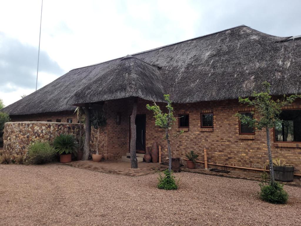 a large brick building with a thatched roof at Makhato Bush Lodge 118 in Bela-Bela