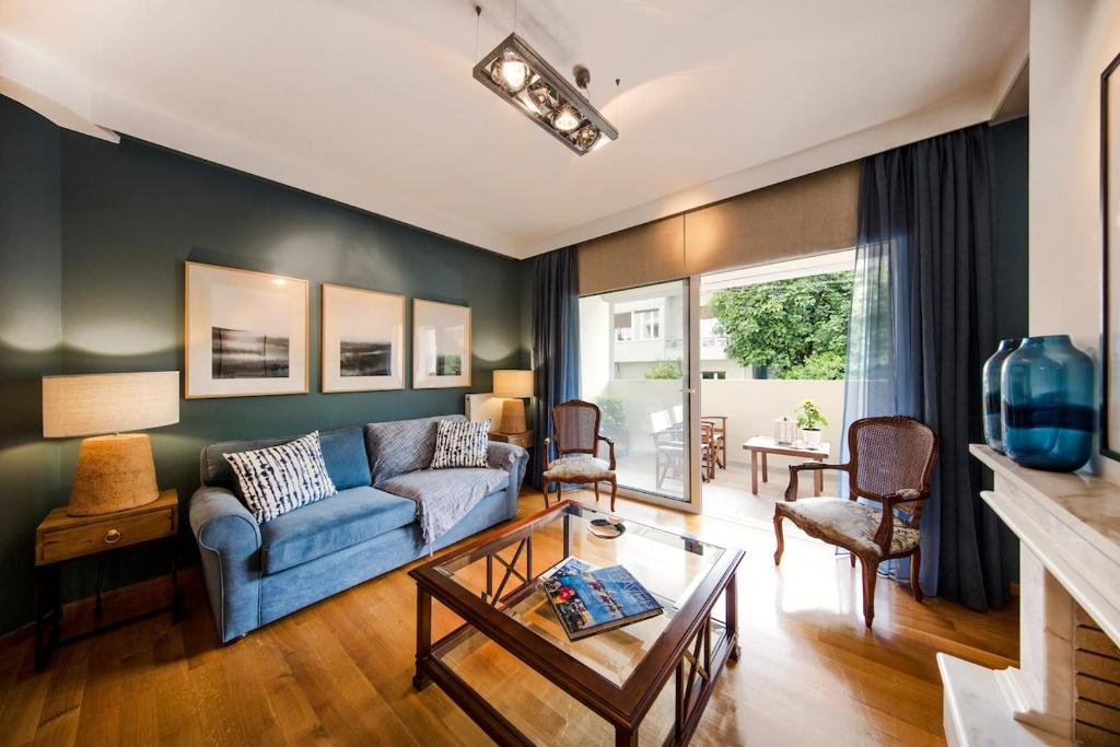 uma sala de estar com um sofá azul e uma mesa em 2 bedroom flat next to Acropolis em Atenas
