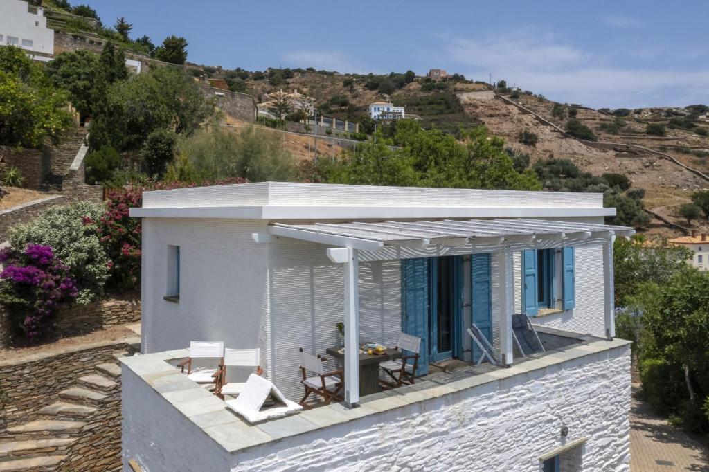 a small white house with a roof at The White House by the beach in Andros