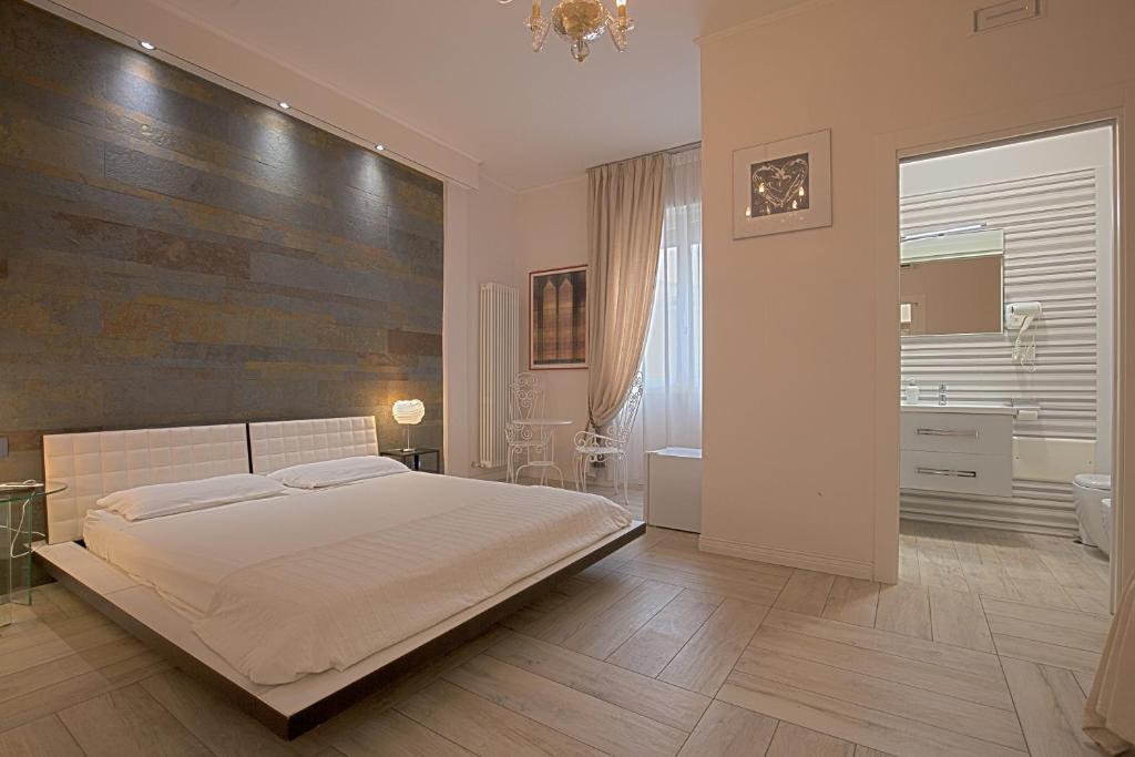 a bedroom with a large bed and a bathroom at Al Teatro Suites in Foggia