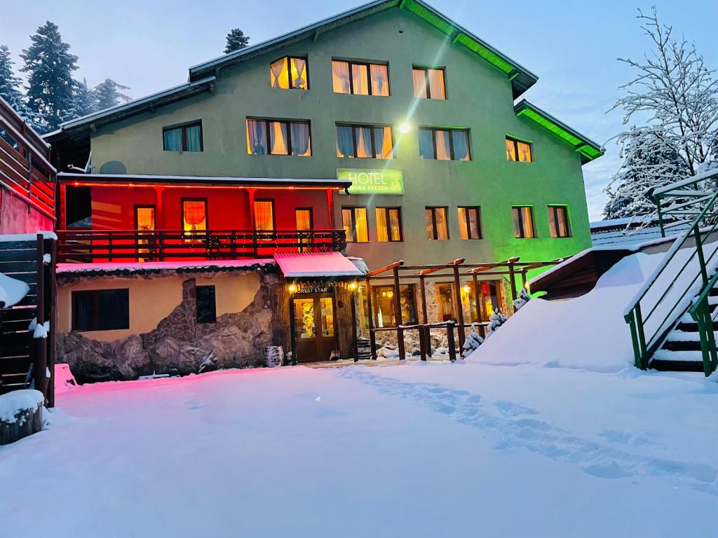 a large building with snow in front of it at Hotel Forest Star on the Ski Slope in Borovets