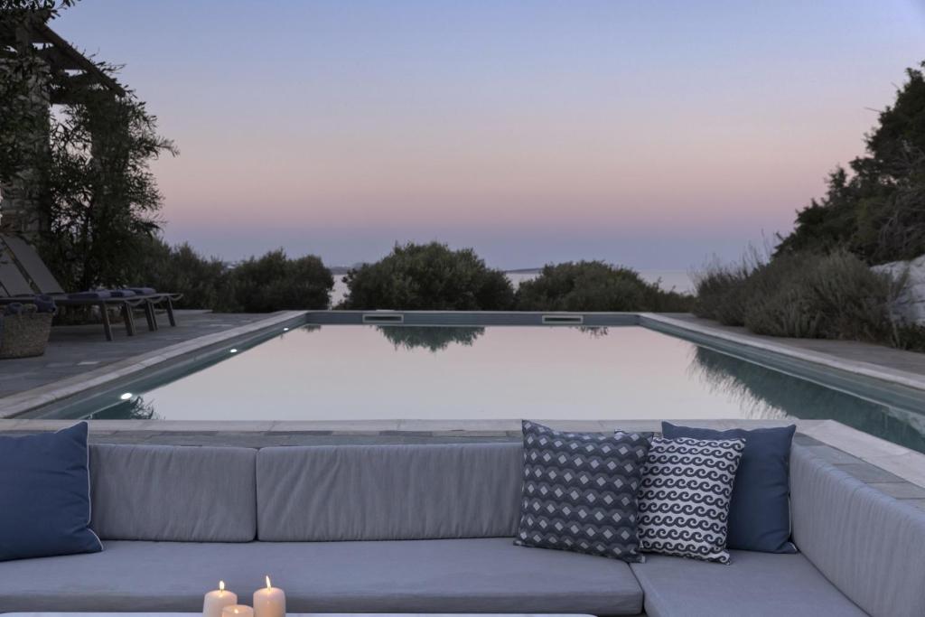 eine Couch vor einem Pool in der Unterkunft Villa Alkyoni · Beautiful 8-person Family Villa with Great Views in Naoussa
