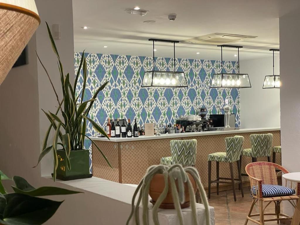 a restaurant with a bar with blue and white wallpaper at Boutique Hotel El Tio Kiko in Agua Amarga