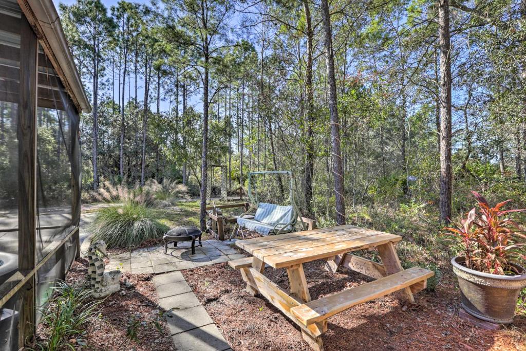 a wooden picnic table and bench in a yard at Keaton Beach Escape with Hot Tub 2 Mi to Shore in Perry
